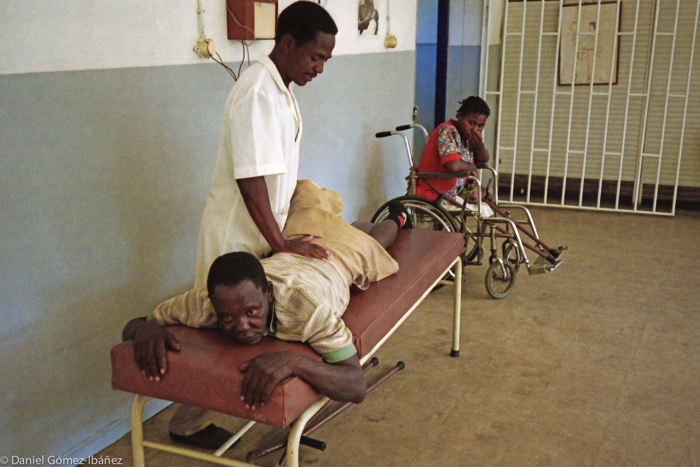 Until now Paolo Chichava has relied on his one leg and the two crutches that lie beneath the table. Carolina Ferrão, 34, watches. She lost both legs in a landmine accident. © 1997